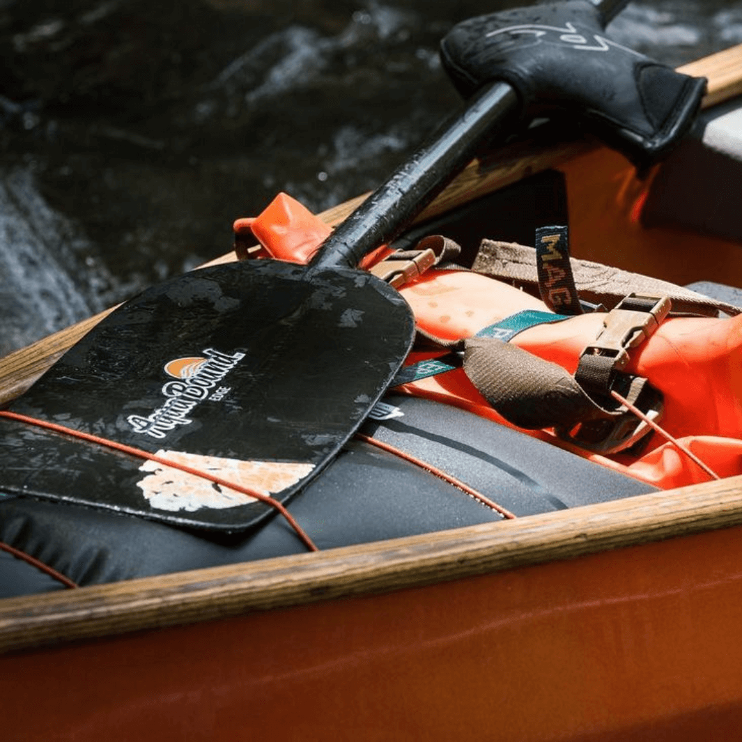 edge 1-piece canoe paddle laying across canoe all packed up