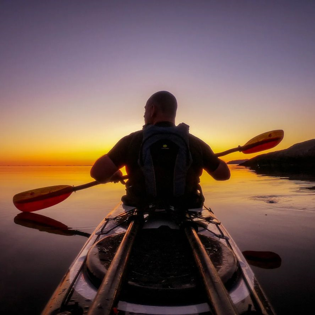 tango fiberglass bent shaft kayak paddle fuego being paddled during sunset photo taken from stern of kayak#color_fuego
