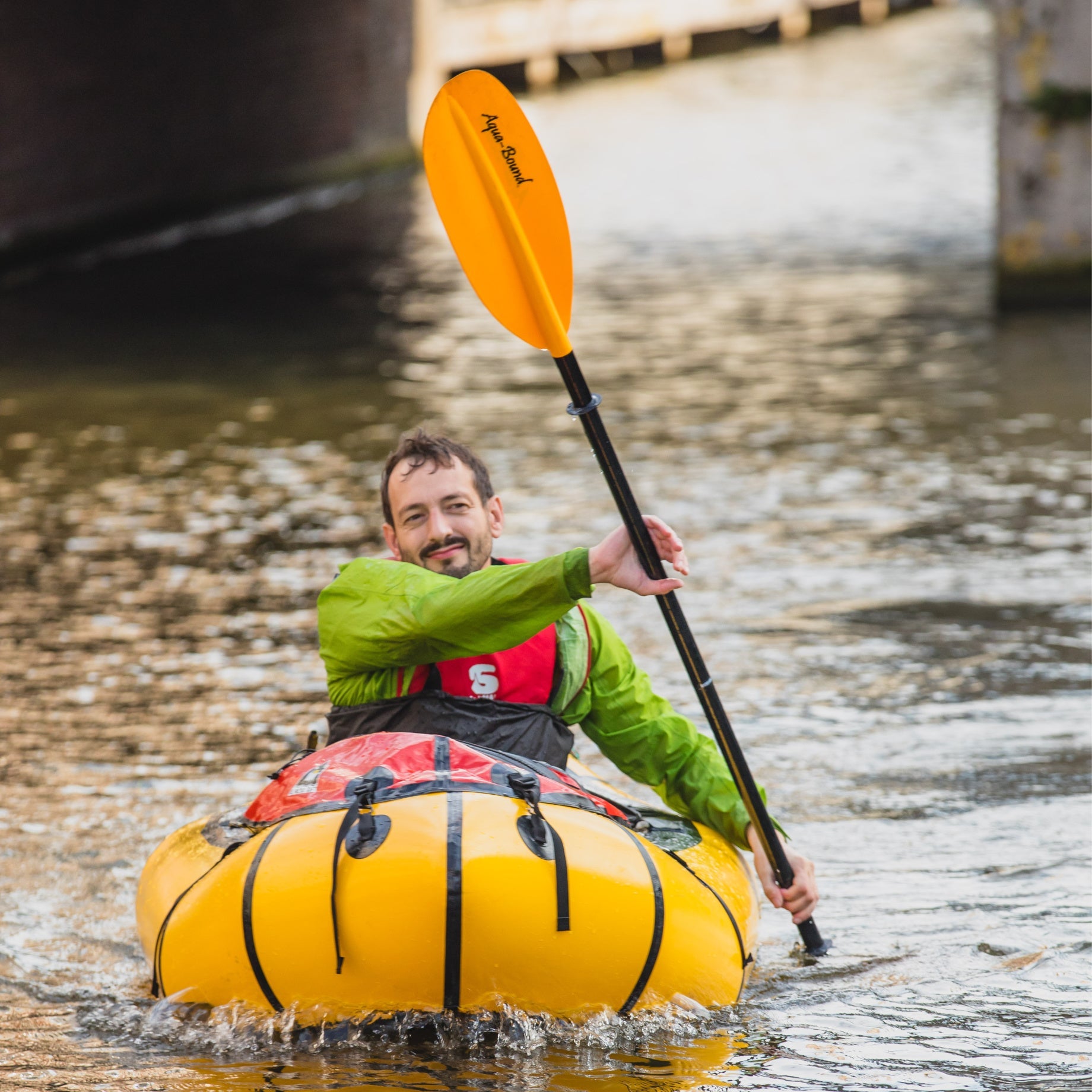 man packrafting in the city with a manta ray fiberglass kayak paddle 