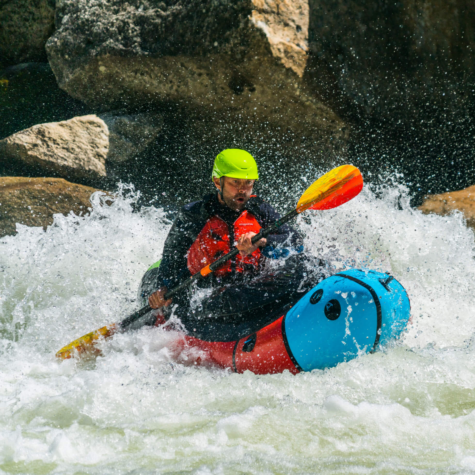 man packrafting on rapids down a river #color_fuego