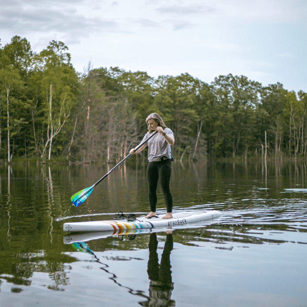 woman paddling a Grey Duck SUP board using the Norther light sup paddle#color_northern-lights