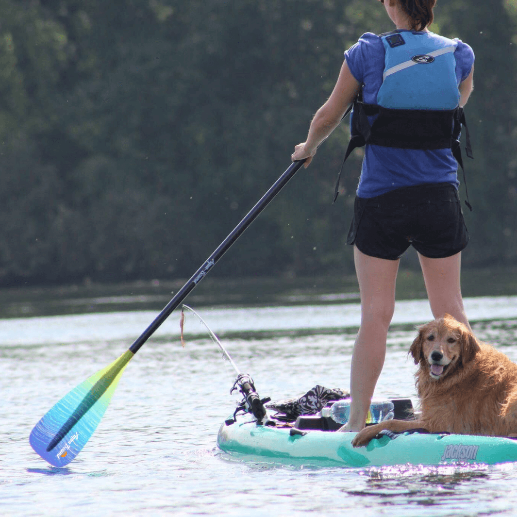 Malta sunwave SUP paddle in use, woman facing away from camera with dog on back of paddle board#color_suwave