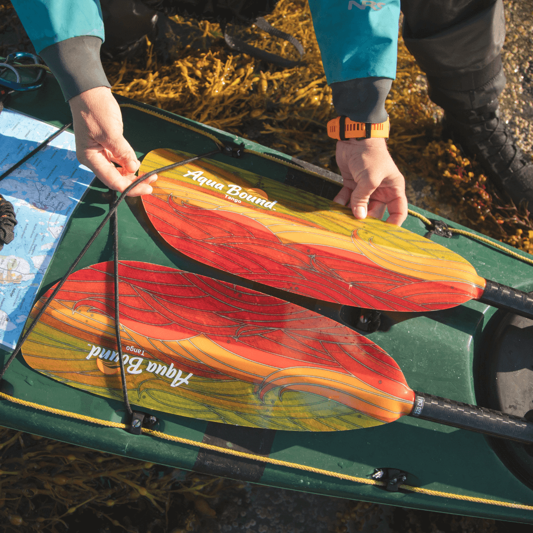 tango fiberglass 2-piece posi-lok kayak paddle fuego strapped in the bungies of a sea kayak#color_fuego
