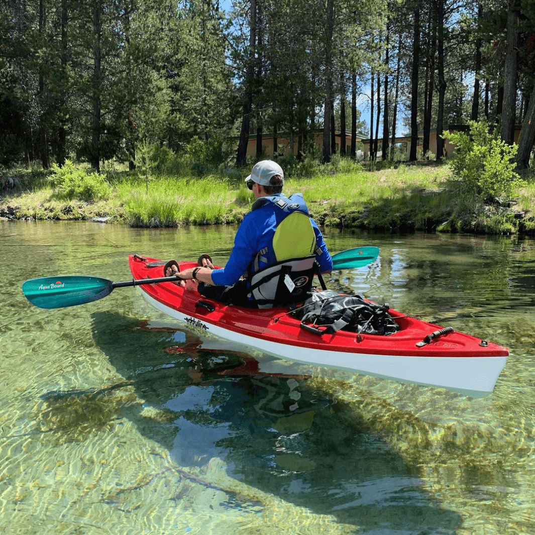 tango fiberglass 2-piece posi-lok kayak paddle green tide being paddled in clear river in red kayak#color_green-tide