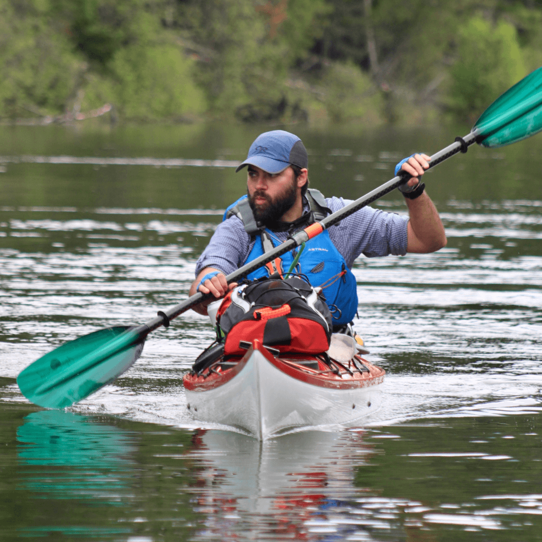 tango fiberglass 4-piece posi-lok kayak paddle green tide being paddled by male kayaker in red kayak#color_green-tide