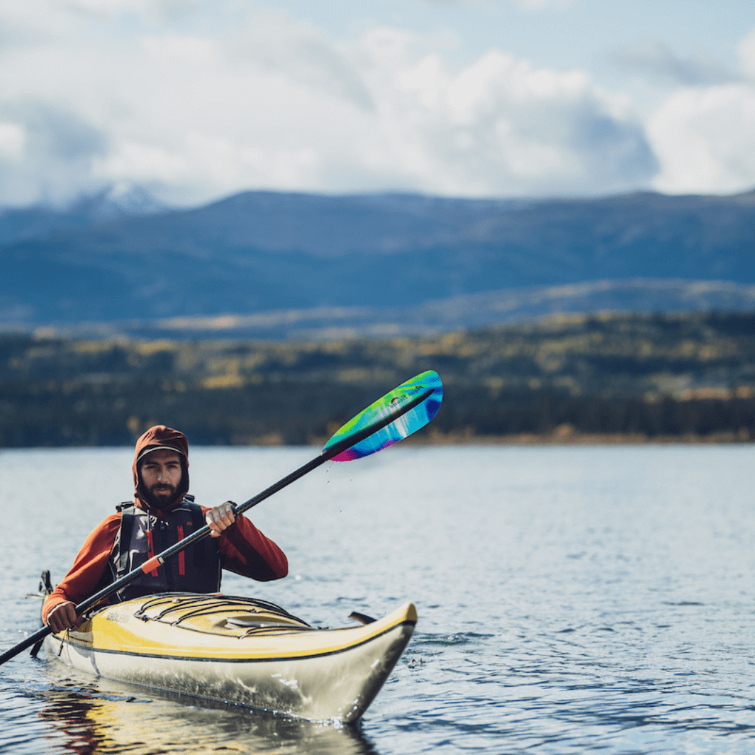 tango fiberglass 4-piece posi-lok kayak paddle northern lights being padded by male in sea kayak#color_northern-lights