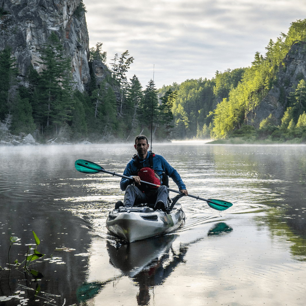 Ken Whiting in a kayak fishing boat using the whiskey green tide paddle foggy background#color_green-tide