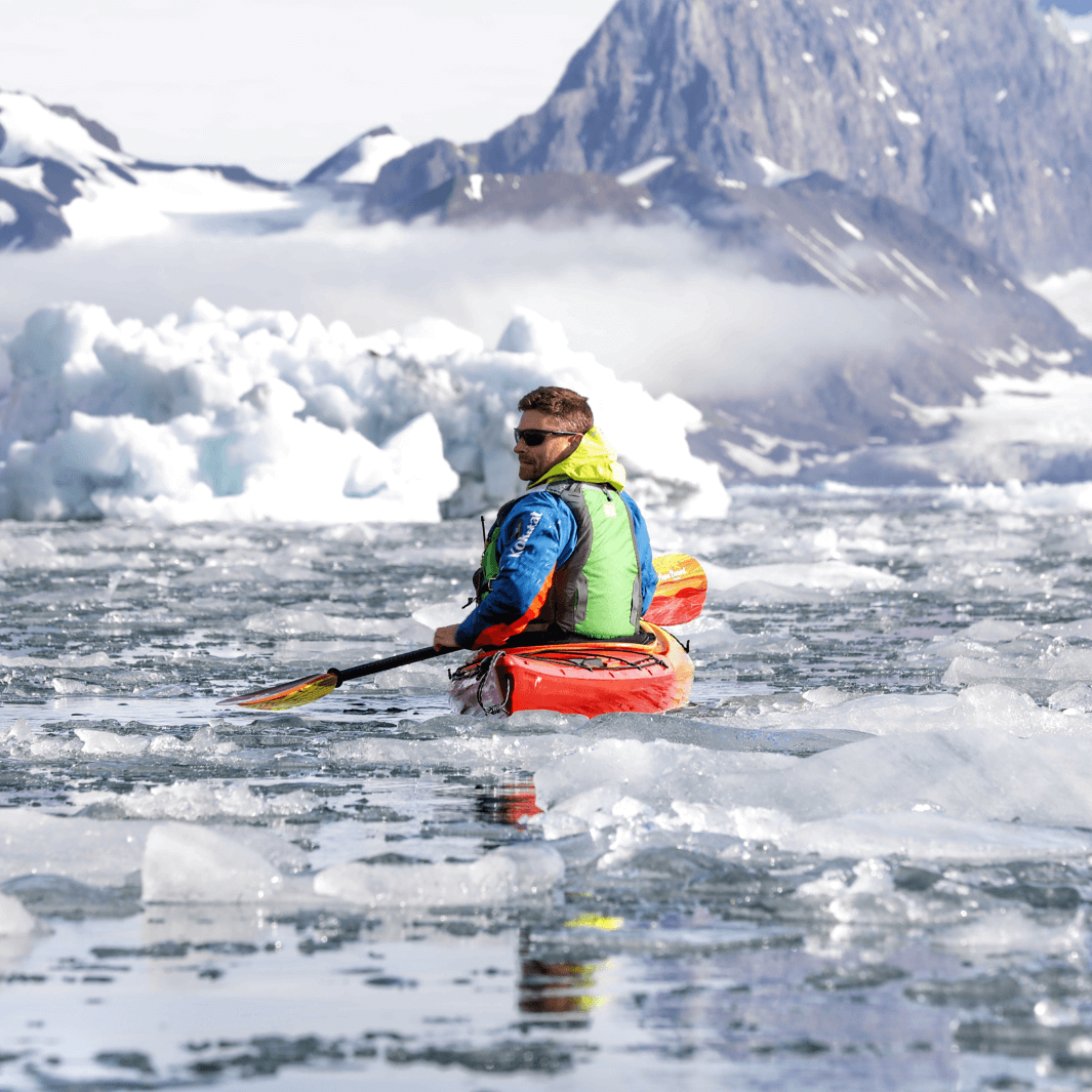 male kayaker in glacial waters with ice and the whiskey fuego paddle#color_fuego