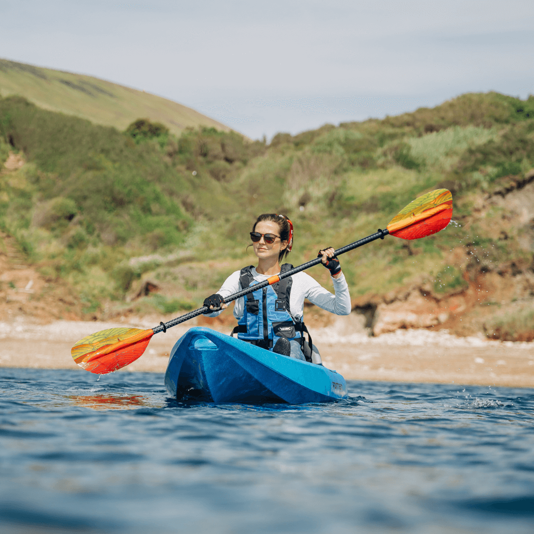 female sea kayaker paddling with the whiskey fuego paddle#color_fuego
